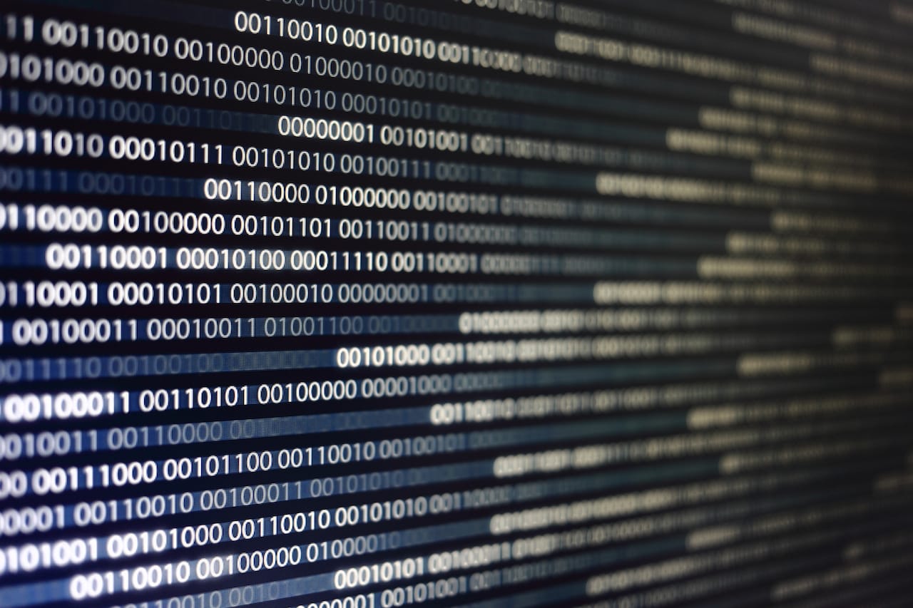 blocks of binary data. Blockchain concept. blue background with computer digital binary code bit number one and zero text. selective focus on the far end of the computer display out of focus in front.