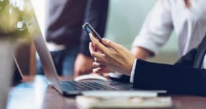 Business woman holding smartphone, using cell phone on office. Technology for communication concept.